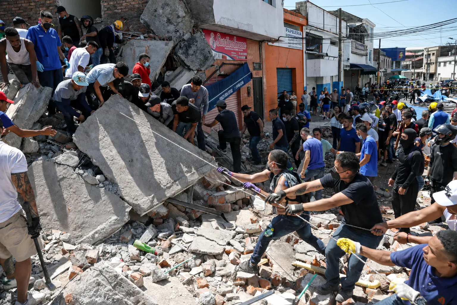 Neighbours in a line, lifting a concrete slab off the rubble by hand